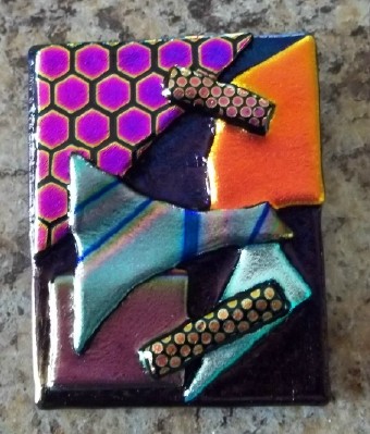 abstract pin or pendant handcrafted in dichroic glass in the USA